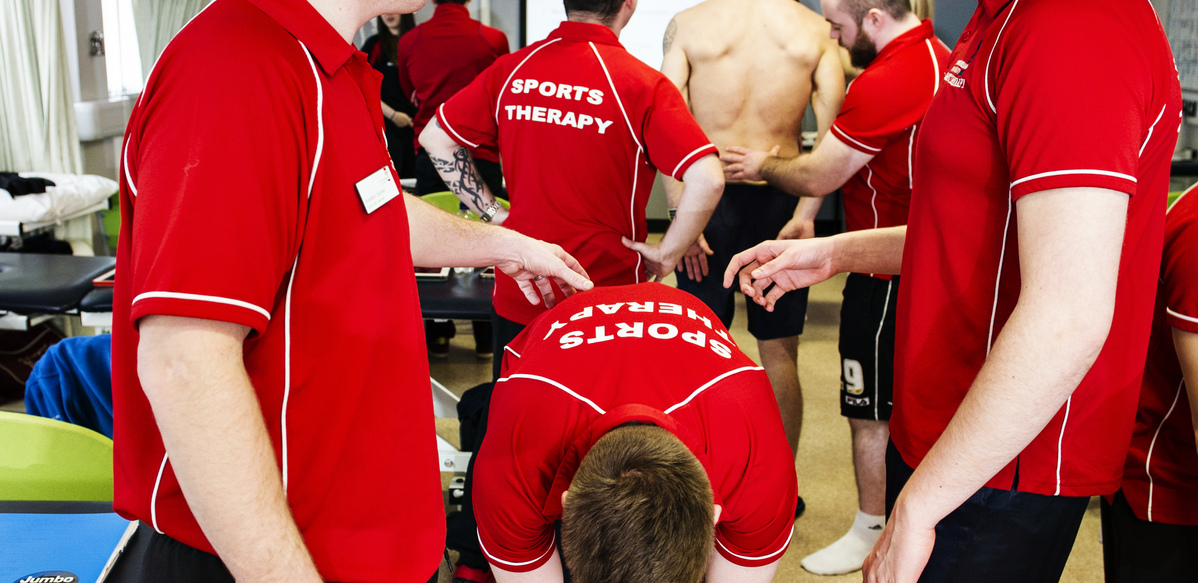 Students practicing sports therapy techniques with each other
