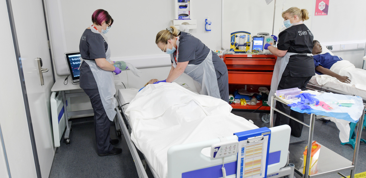 Student nurse practicing giving CPR to a patient manikin