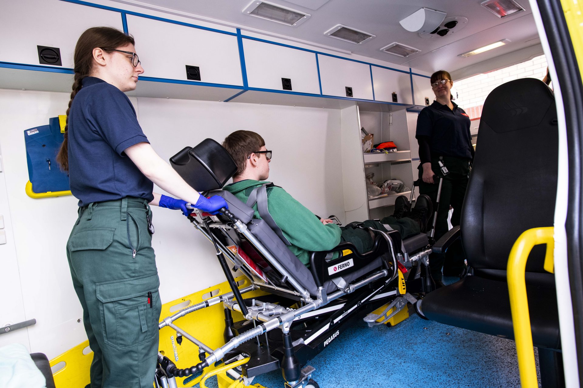 A student helping to remove a patient (played by an actor) from an ambulance on a trolley.