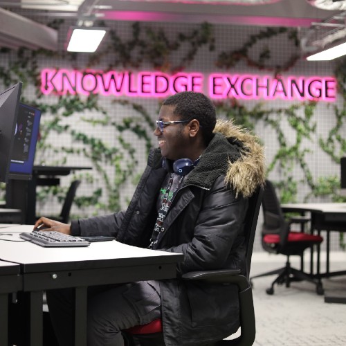 A student sitting at a computer in the Knowledge Exchange.