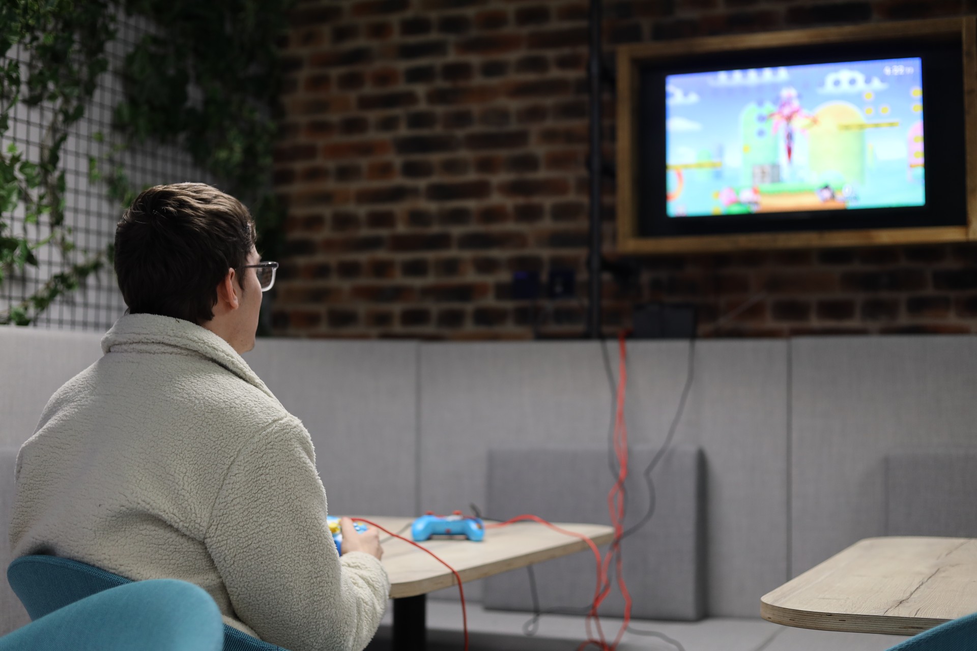 A student playing a console game in Reload.